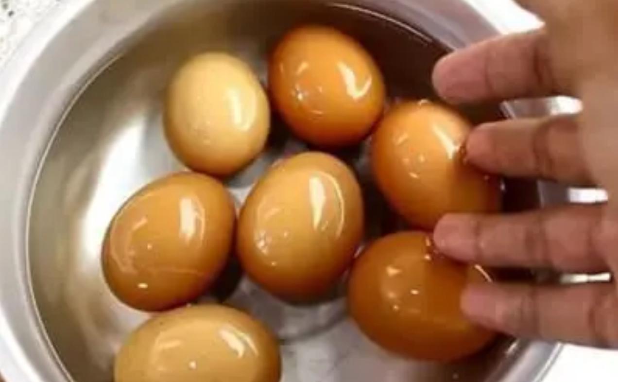 Ovos marinados em molho de soja num recipiente de inox — snack proteico